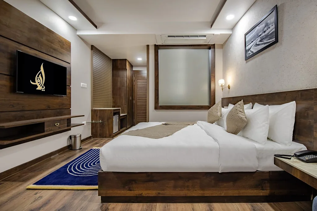 A Premium Room with a double bed, wood-panelled walls and a wall-mounted television