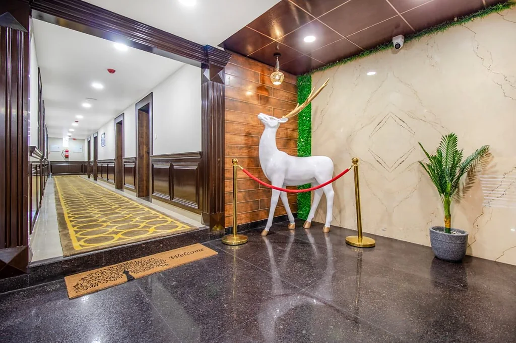The ground-floor corridor, with a welcome mat, potted palm and a white deer sculpture